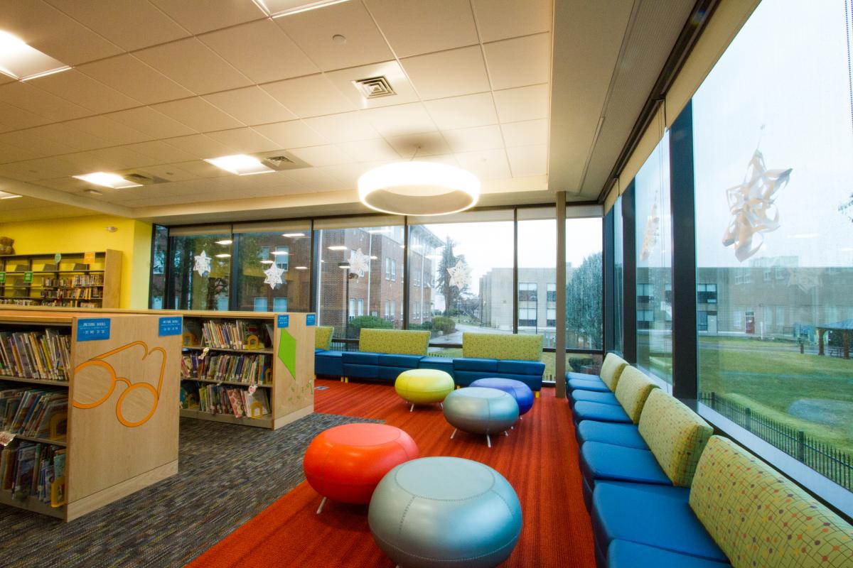 Variety of Funky Chairs and Seating Next to Exterior Windows and Childrens Books 1