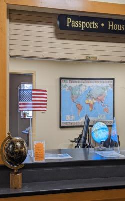 Office with passports sign, desk, flag, globe, and map
